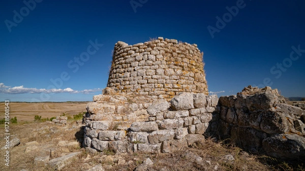 Fototapeta Nuraghe Piscu megalithic stone tower ruins in Suelli, Sardinia, under clear blue sky