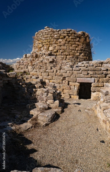 Fototapeta Nuraghe Piscu megalithic stone tower ruins in Suelli, Sardinia, under clear blue sky