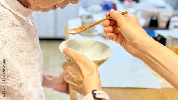 Fototapeta 高齢女性に食事介助する女性の手_横から