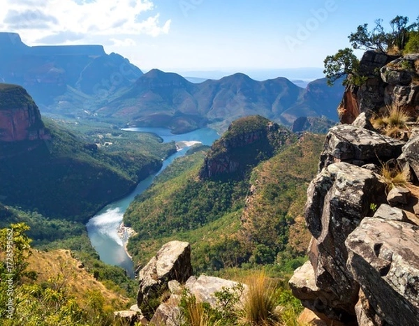 Obraz Panoramic vista of a valley carved by a river, surrounded by mountains