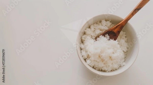 Fototapeta Rice, Wooden Spoon, and Bowl – a warm and rustic composition. The natural textures and earthy tones create a cozy, homey kitchen atmosphere.
