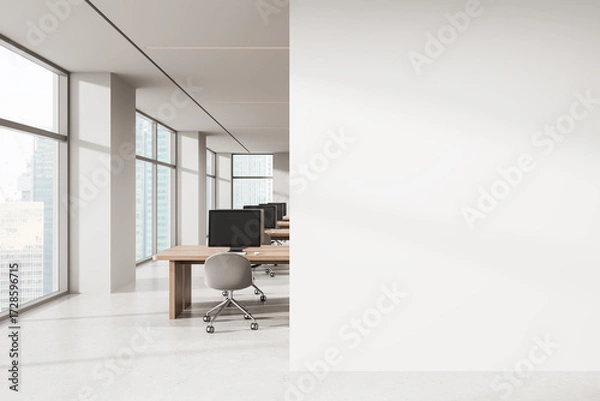 Fototapeta Open space office with row of workstations and large blank wall for advertising or poster mockup concept in modern high-rise interior setting. 3D Rendering