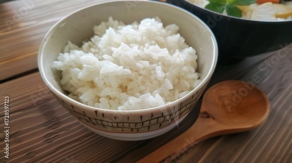 Fototapeta Rice, Wooden Spoon, and Bowl – a warm and rustic composition. The natural textures and earthy tones create a cozy, homey kitchen atmosphere.