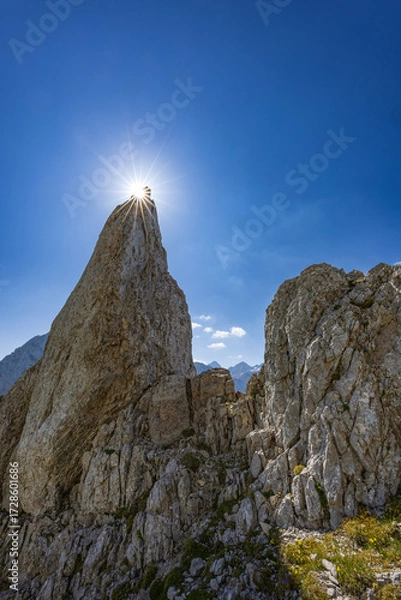 Fototapeta Dramatic view of Babe rock formation near Kamniško sedlo, Slovenia, with rugged alpine terrain, clear skies, and a scenic mountain hiking trail.