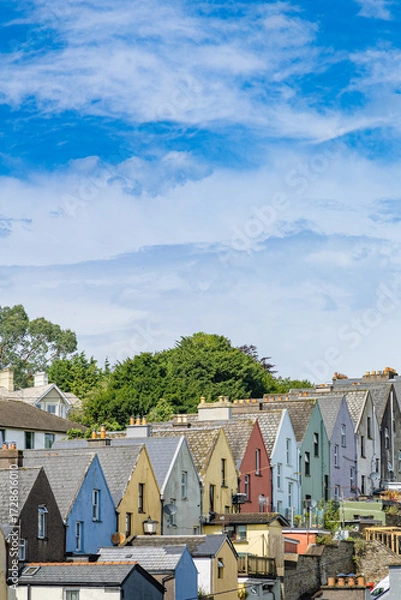 Fototapeta A stunning view of the iconic colorful houses in Cobh, Ireland. These vibrant row houses create a picturesque scene against the backdrop of this charming coastal town.