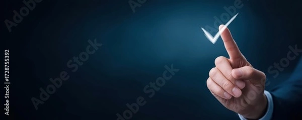 Fototapeta  hand points to a glowing check mark against a dark background, symbolizing approval or confirmation.