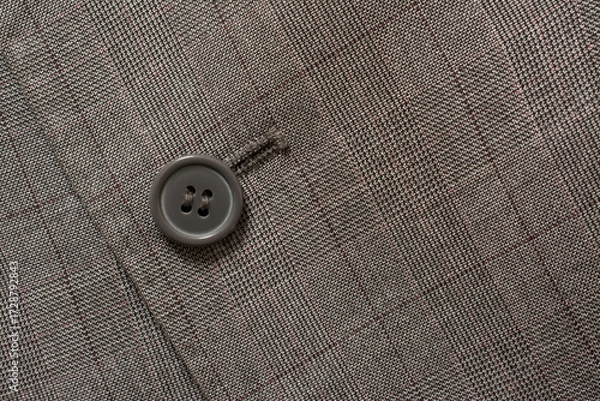 Fototapeta Detail of closeup of suit button on pin stripped cloth. Tailoring background