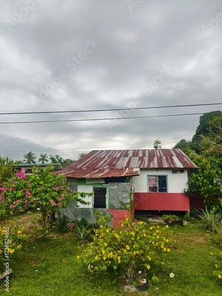 Fototapeta Rustic Cottage With Rusty Roof Surrounded By Lush Garde