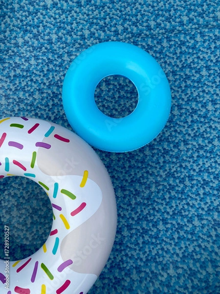 Fototapeta Pool float donut and blue circle in swimming pool. Water safety.  Top view. 