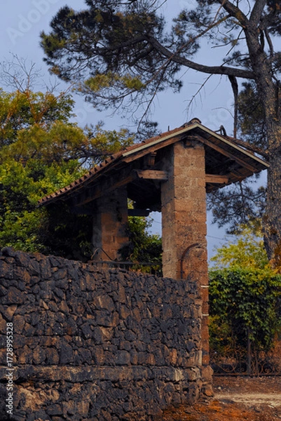 Fototapeta A beautifully scenic stone archway is surrounded by lush and vibrant greenery all around