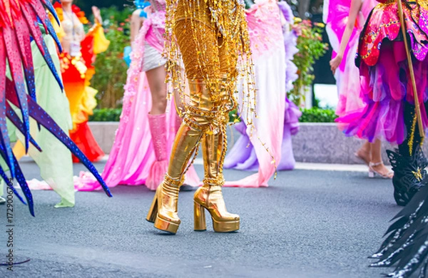 Fototapeta A cropped photo shows the lower body of female participants at the Nha Trang Sea Festival parade, featuring elements of their costumes, detailed accessories, and extravagant footwear.