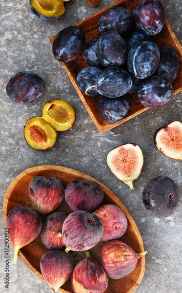Obraz Fresh plums and figs on the wooden plates