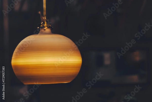 Obraz アンティーク調のペンダントライトが夜の部屋で光っている
