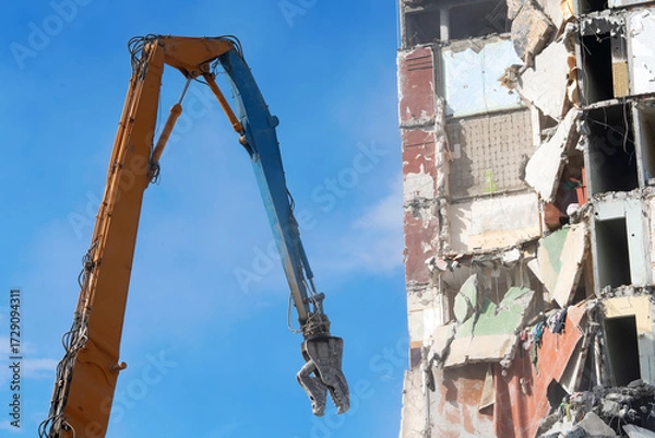 Fototapeta Demolition of multi-story building with heavy machinery equipment.