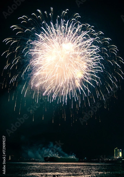 Fototapeta Vietnam, Nha Trang -07 June 2025:A luxurious fireworks display is launched from a ship along Nha Trang's coast, with lights illuminating water, creating a celebration scene for beach spectators.