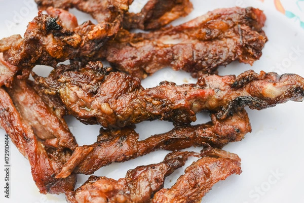 Fototapeta close-up overhead shot of several pieces of cooked, grilled, or fried meat served on a plate