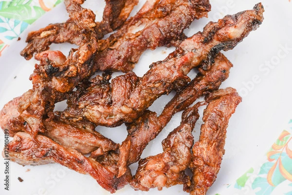 Fototapeta close-up overhead shot of several pieces of cooked, grilled, or fried meat served on a plate