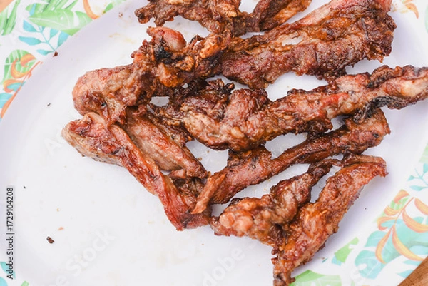 Fototapeta close-up overhead shot of several pieces of cooked, grilled, or fried meat served on a plate