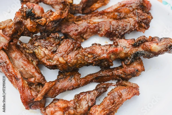 Fototapeta close-up overhead shot of several pieces of cooked, grilled, or fried meat served on a plate