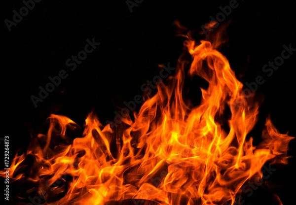 Fototapeta Powerful flames dancing against the night, an intense blaze perfect for dramatic backgrounds, fiery designs, and conveying passion and energy in your project