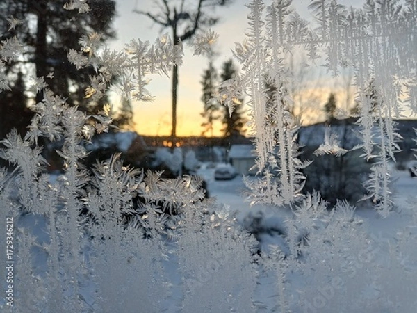 Fototapeta Frost patterns on frozen winter window as a symbol of Christmas wonder. In the middle of the window is a misted space for your product or lettering.
