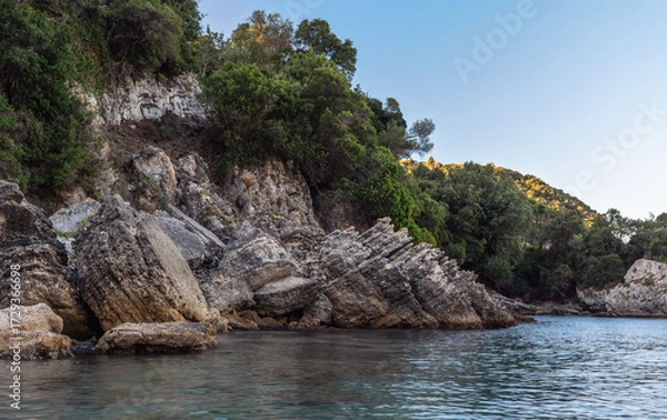 Obraz Calm sea at shore with large rocks, typical scenery at one of many bays in Liapades, Greece