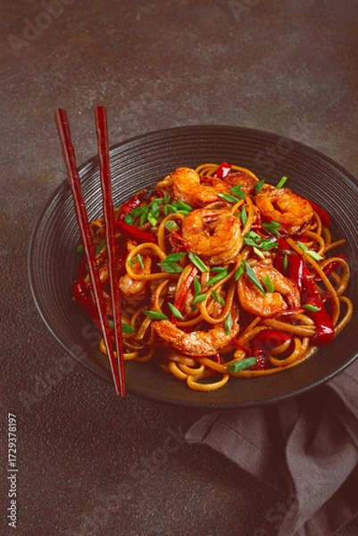 Obraz udon stir-fry shrimp noodles with red bell pepper and green onion, served in a black bowl, with chopsticks, dark background,