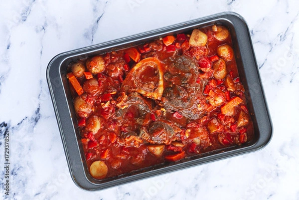 Obraz ossobuco stew with vegetables, knuckle on the bone with new potatoes, in tomato sauce,homemade, top view, no people,