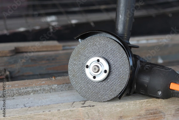 Fototapeta Angle grinder with battery. Power tool close-up. Angle grinder on the veranda. Repair and construction tool. Angle grinder with handle