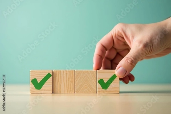 Fototapeta Quality control and successful task completion concept. Hand places a wooden block with green check mark for approval.