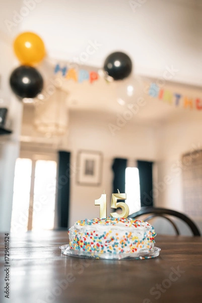 Fototapeta 15 year old's birthday cake in dining room decorated with balloons and bunting
