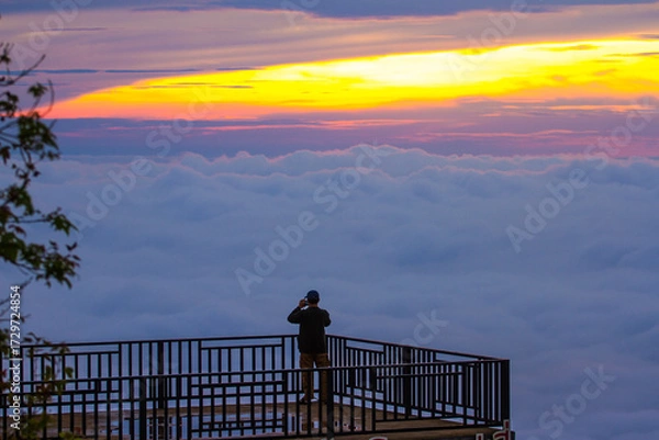 Fototapeta silhouette of a man standing on terrace with sea of mist