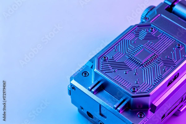 Obraz Close-up of a futuristic electronic device with circuit patterns illuminated by neon blue and purple lighting