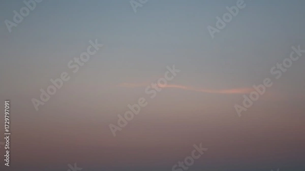 Fototapeta Small clouds and pink and blue colored sky in the background.