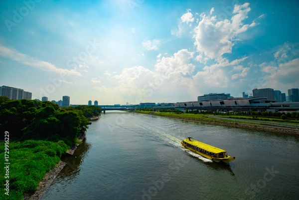 Fototapeta A cityscape of floating ship on the creek in Tokyo wide shot