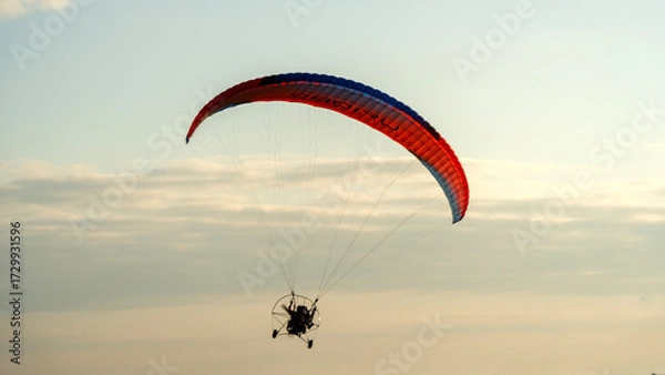 Obraz Moto glider with parachute on sunset background