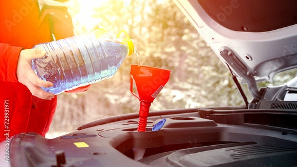 Obraz Driver pours windshield fluid in winter