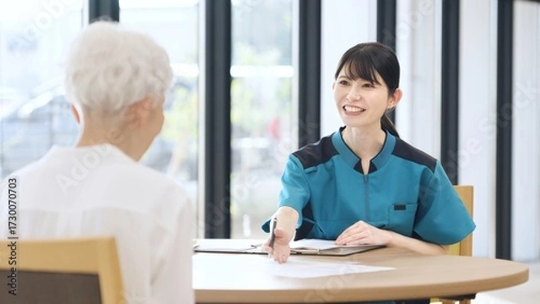 Obraz 介護施設の説明をするアジア人介護士