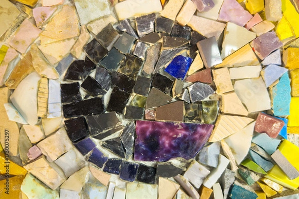 Fototapeta Jagged broken stone pieces in various shades forms a textured base. Shimmering, iridescent fragments are meticulously arranged in a circular pattern. Natural decorative mosaic elements background.