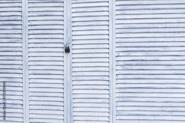 Fototapeta Abstract background of light painted planks of shutters, gates locked. Aged wood surface texture. A copy of the space.