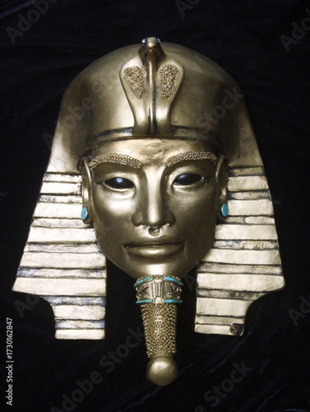 Fototapeta Golden pharaoh mask sculpture with turquoise accents, featuring alien-inspired eyes. A mysterious blend of ancient Egyptian symbolism and cosmic allure. Unique contemporary sculpture.