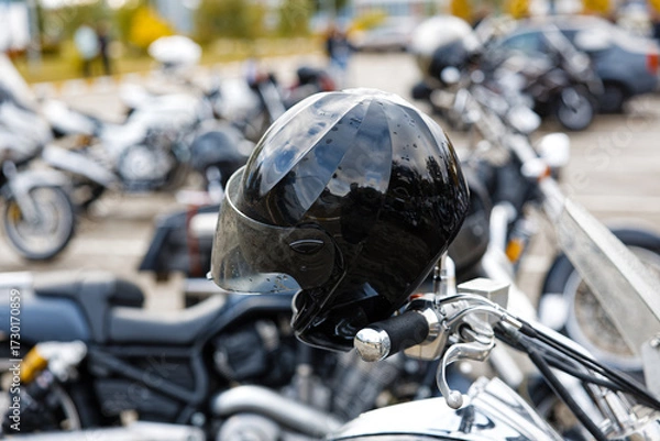 Fototapeta Closeup black moto helmet on motorcycle handlebars against blurred background. Shallow focus.