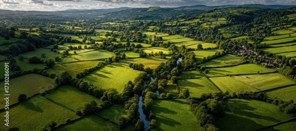 Fototapeta Scenic Aerial View of Lush Green Fields and River in Countryside