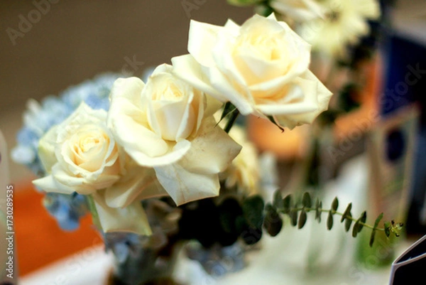 Fototapeta Close up of white roses in vase on table, table decoration