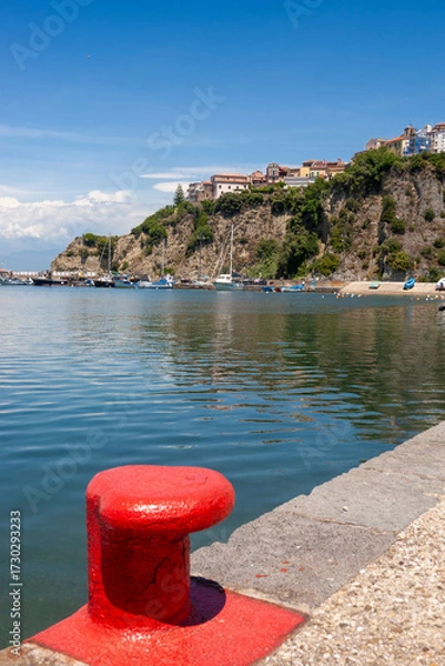 Fototapeta The harbour of Agropoli, Campania, Italy, with a red-painted bollard on the quayside in the foreground