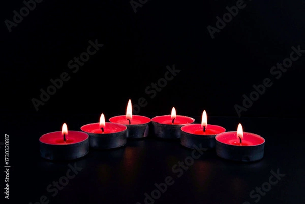 Obraz red candles on black background
