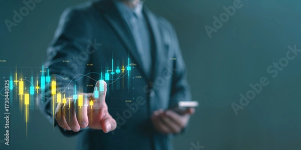 Fototapeta Businessman or trader analyzing digital candlestick chart on virtual screen, representing stock trading, financial investment, market analysis, forex, crypto, and economic data visualization.