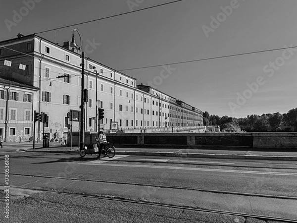 Fototapeta Rome, Italy - June 20, 2025, view of the large complex The complex of S. Michele a Ripa which runs along the entire front of the Porto di Ripa Grande on the Tiber River, seen from the Ponte Sublicio.