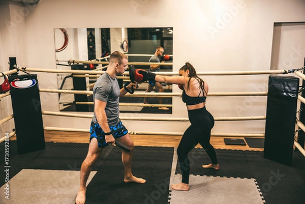 Fototapeta Boxing training session in a gym with focus on technique and strength building for athletes