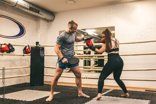 Fototapeta Pair of fighters training in a gym with focus on technique and skill in a boxing ring